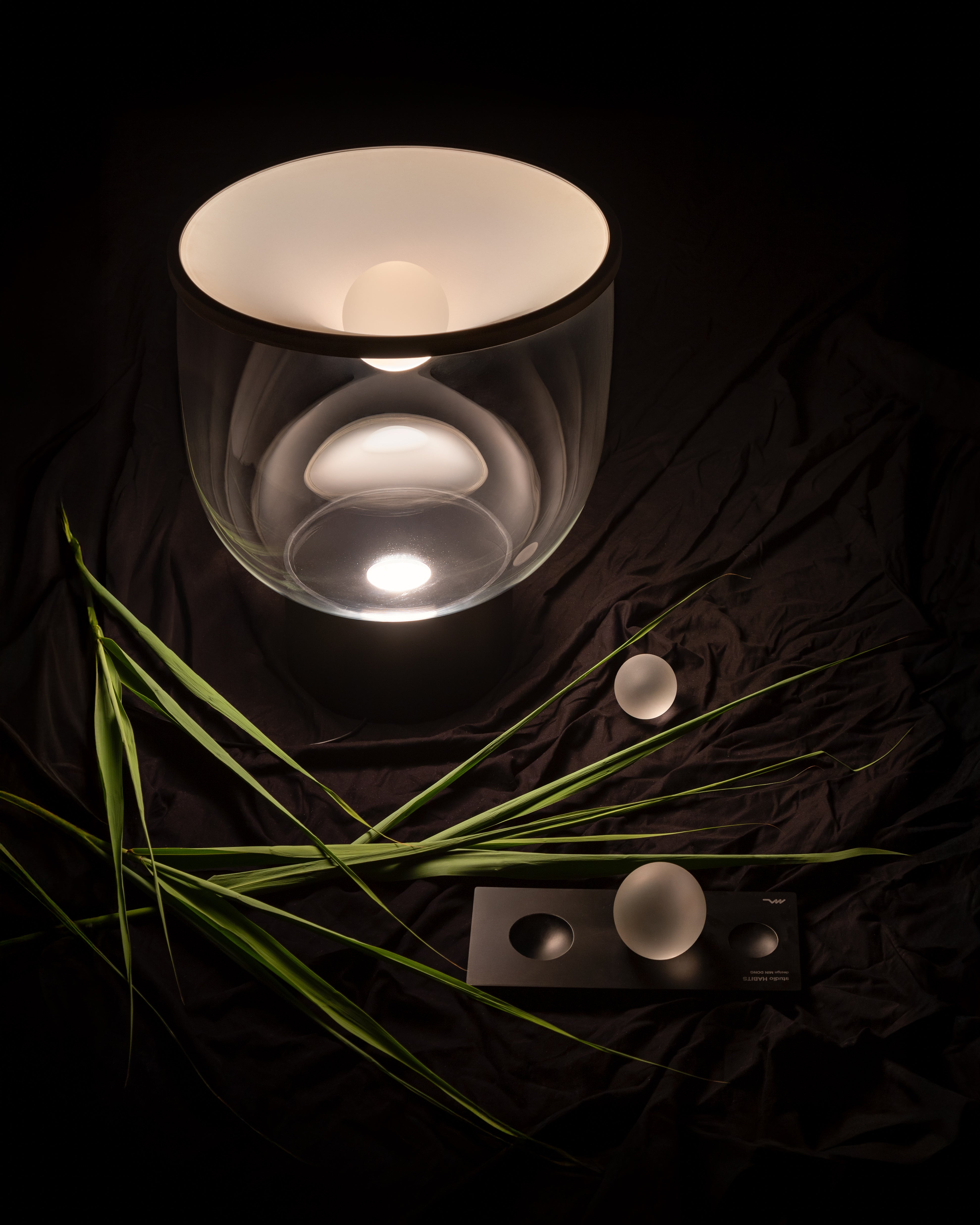 GRAMMOLUCE table lamp with a glass shade and black base.