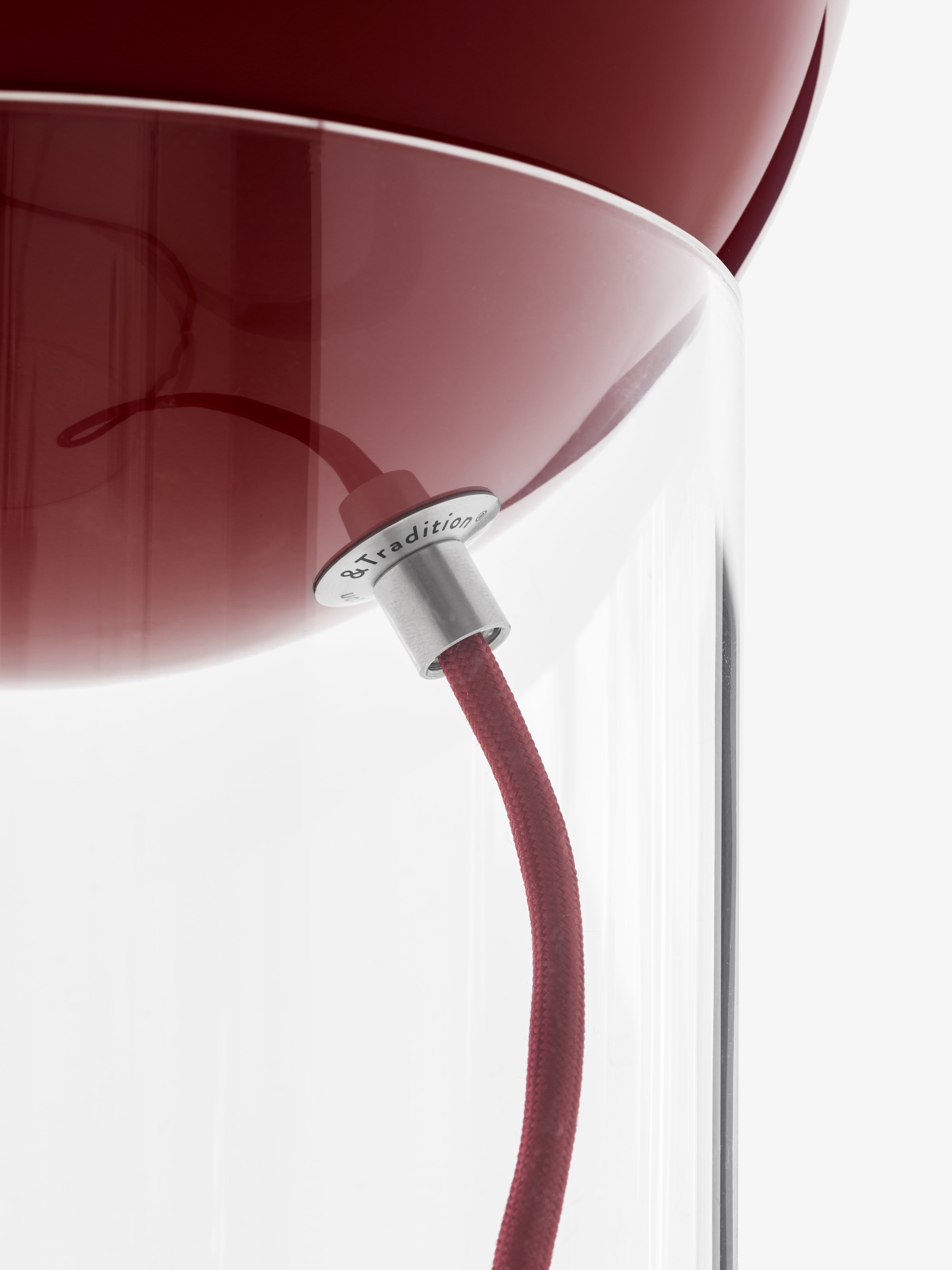Stolná lampa TOPAN s červeným tienidlo a transparentným podstavcom.