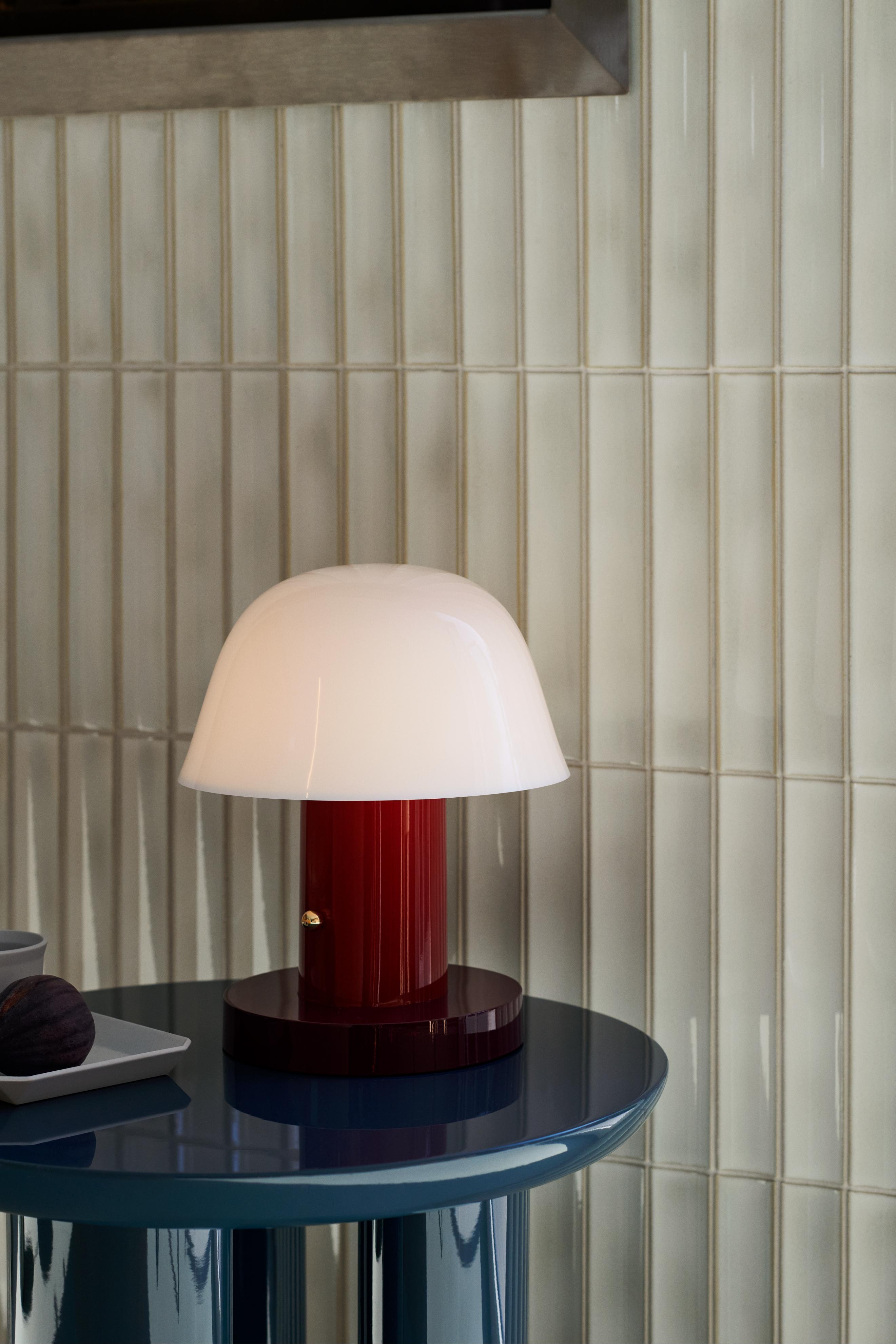 Prenosná lampa SETAGO JH27 s krémovým tienidlo a tmavočerveným podstavcom.