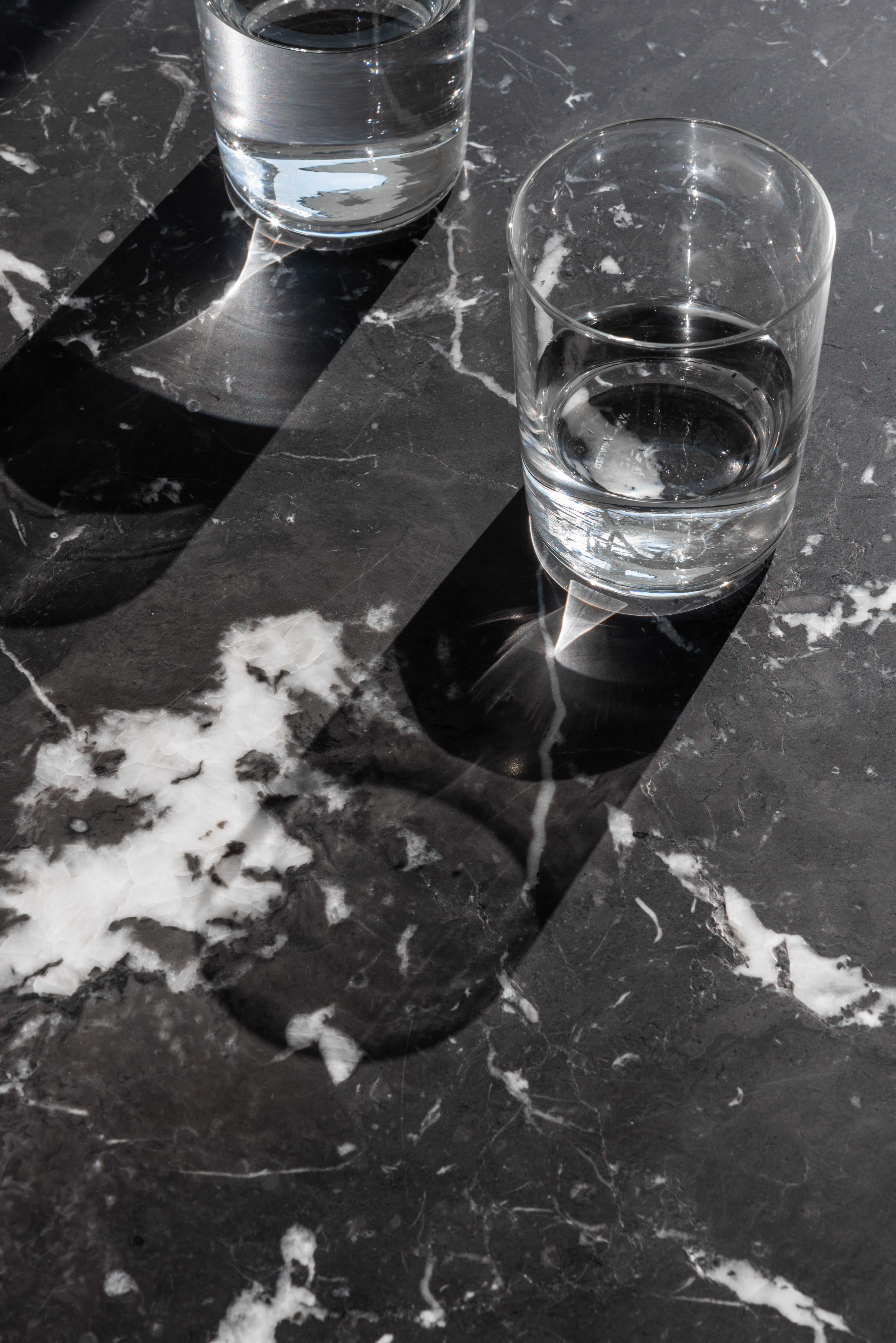 Okrúhly stôl BRUT čierny mramor s červeným podstavcom