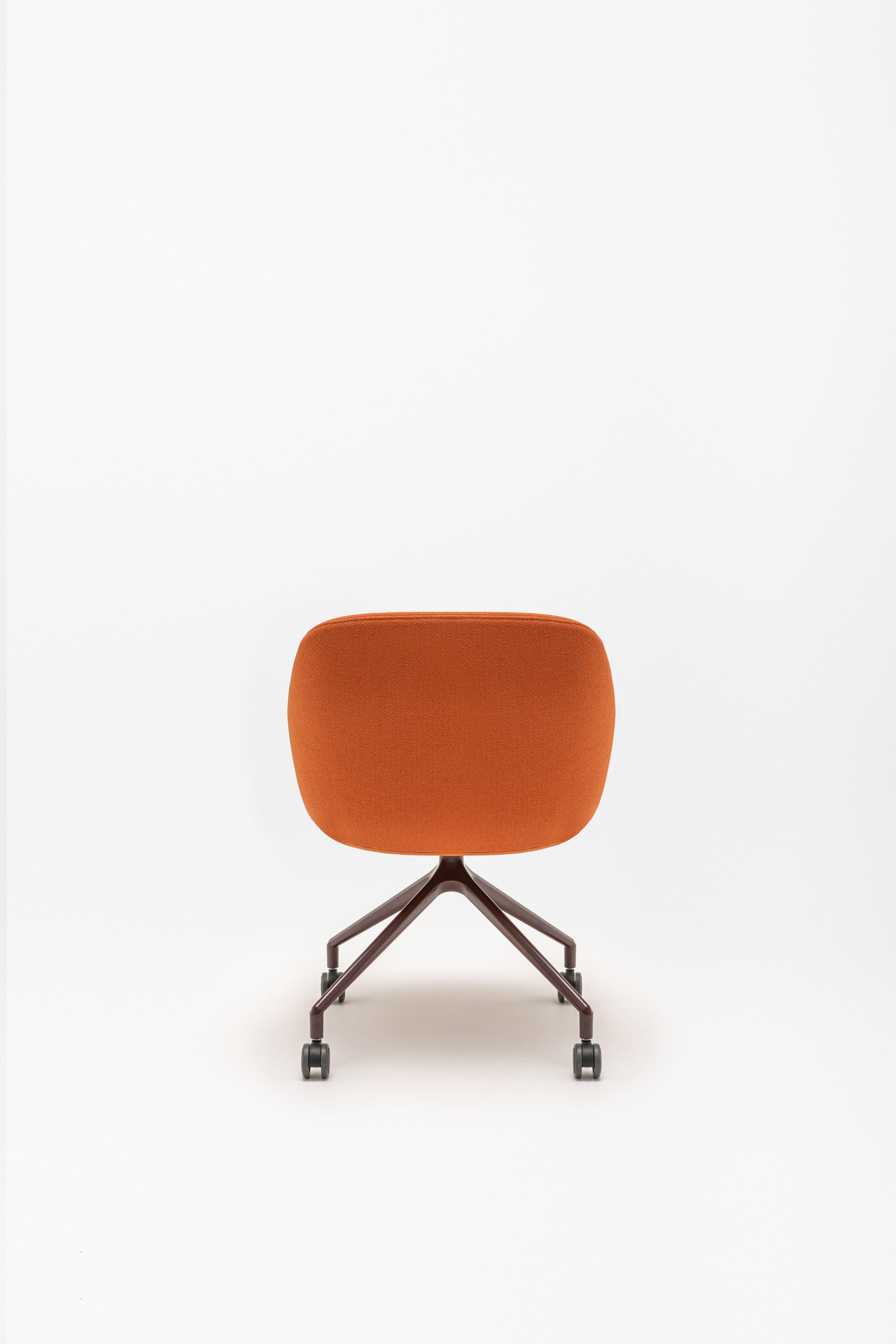 Rotable armchair with low backrest metal parallel base with wheels to a soft surface