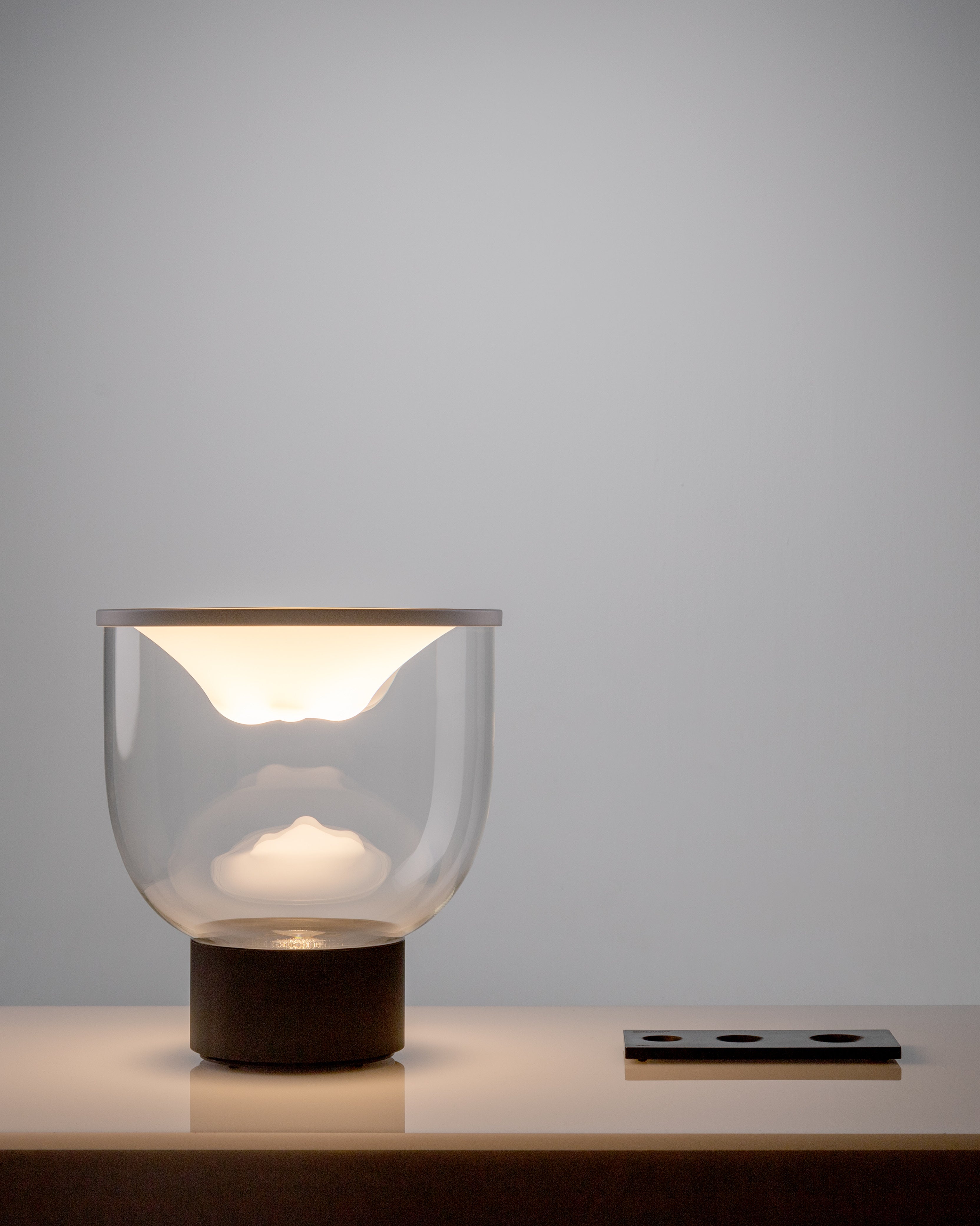 GRAMMOLUCE table lamp with a glass shade and black base.