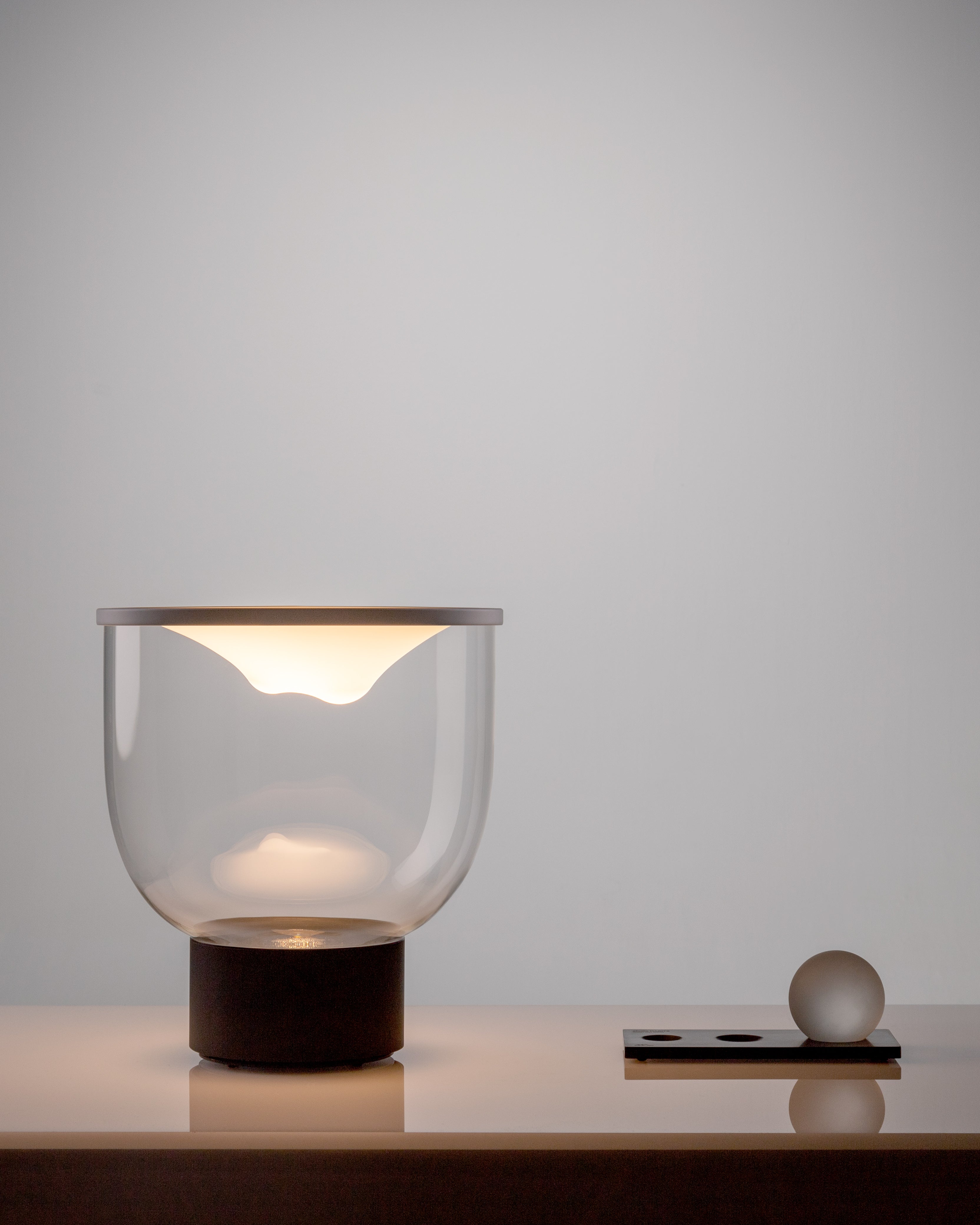 GRAMMOLUCE table lamp with a glass shade and black base.