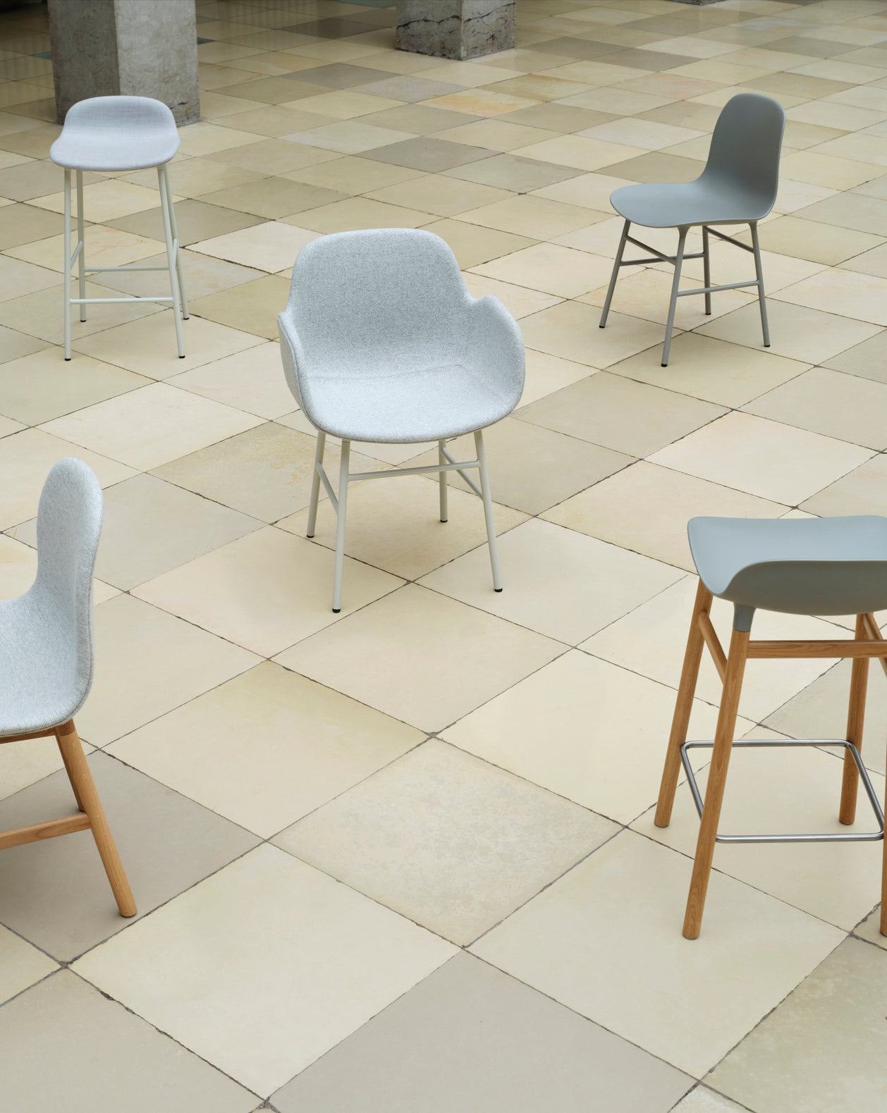 Hocker of light gray forms with an oak base