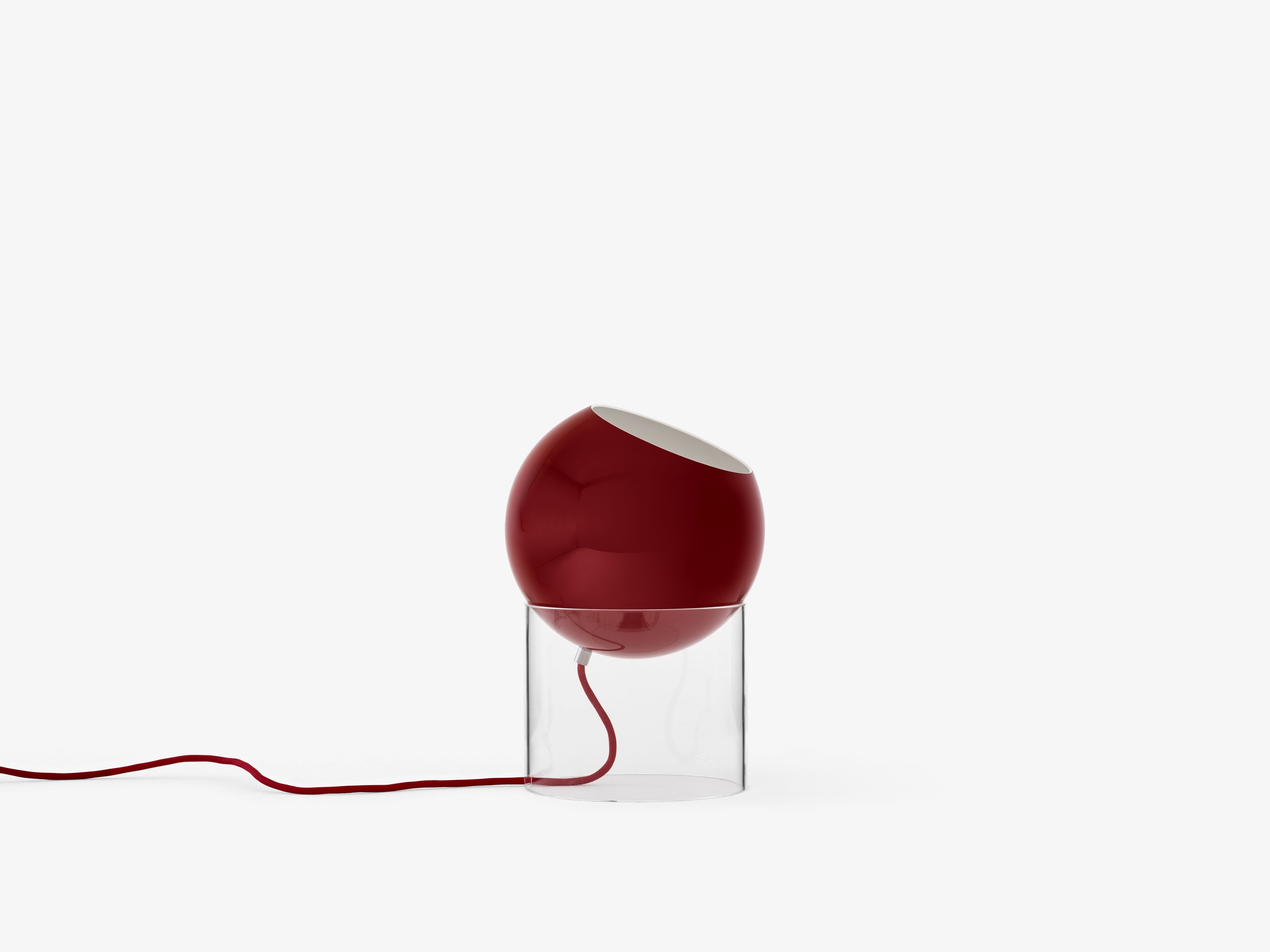 Stolná lampa TOPAN s červeným tienidlo a transparentným podstavcom.