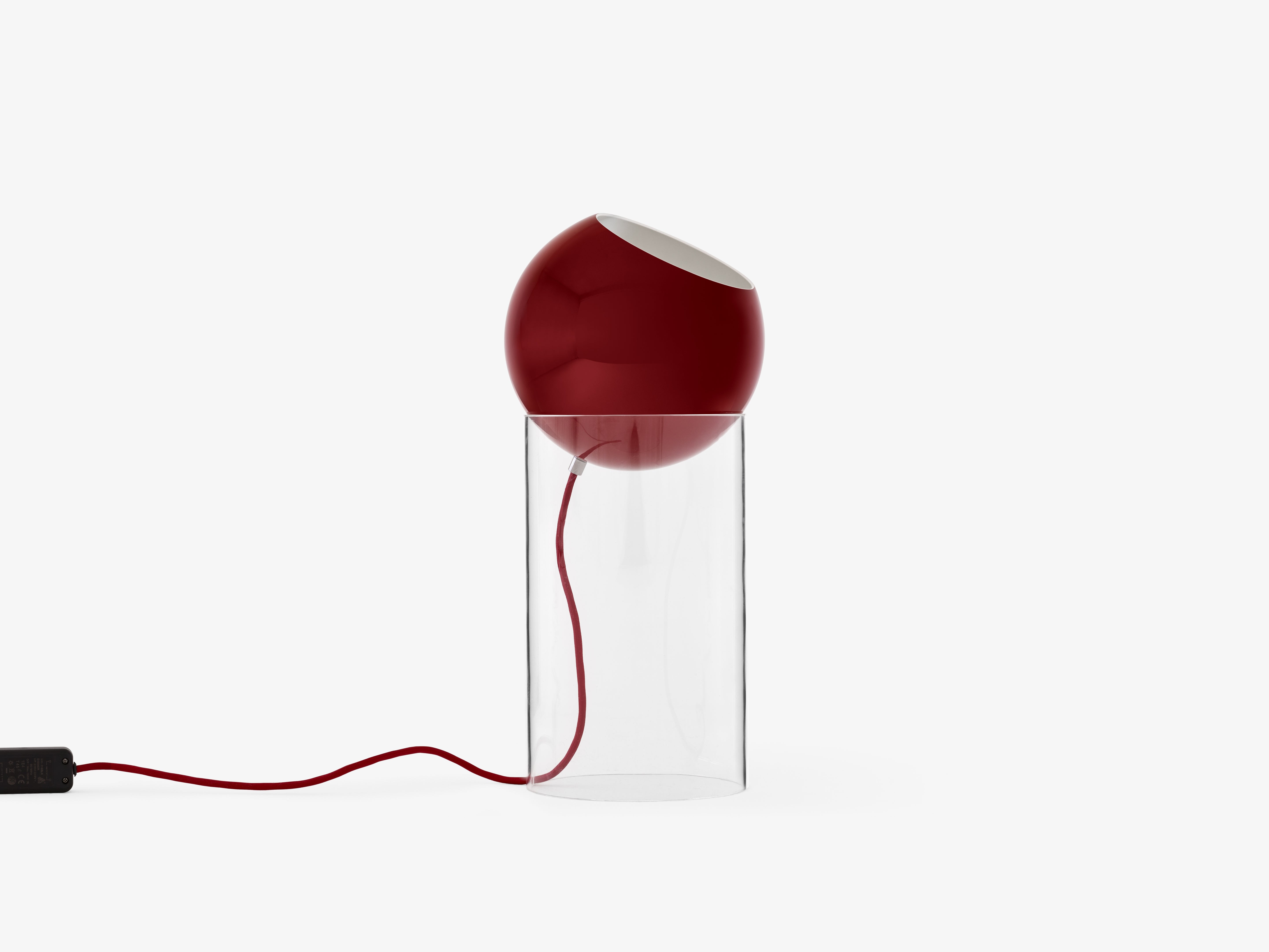 Stolná lampa TOPAN s červeným tienidlo a transparentným podstavcom.