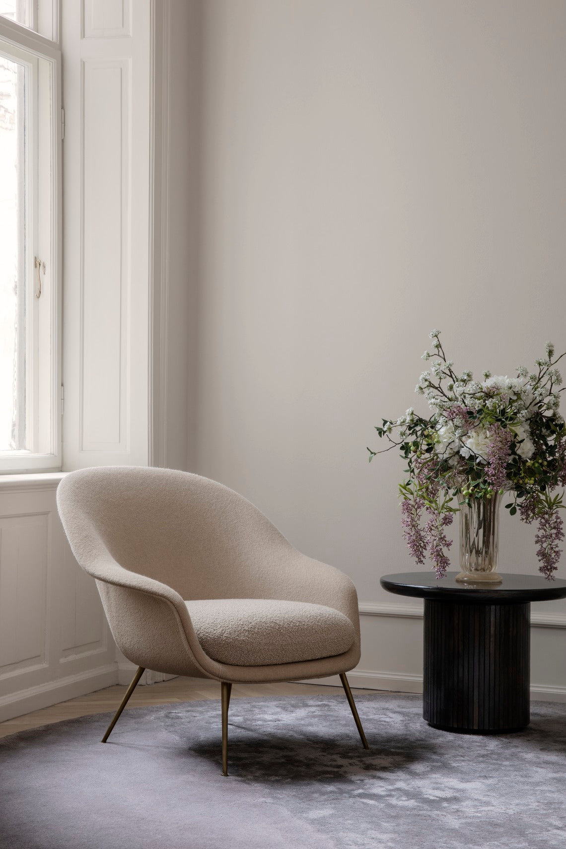 Upholstered BAT armchair with brass base