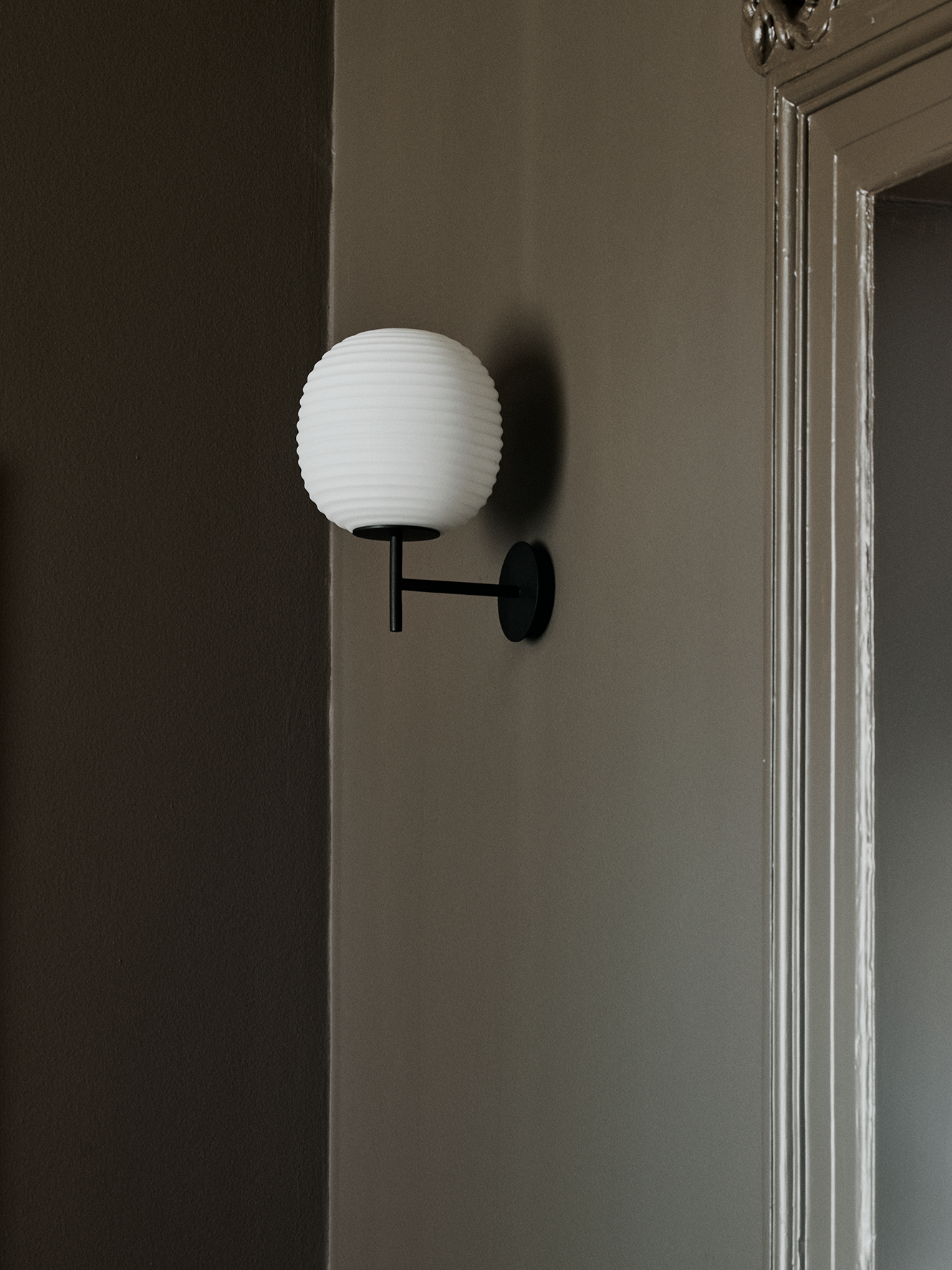 Lantern white wall lamp with a black base
